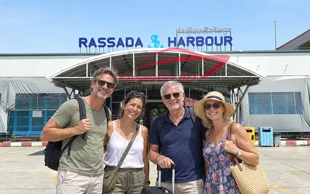 Group of travelers posing in front of the Rassada Harbour main terminal building in Phuket